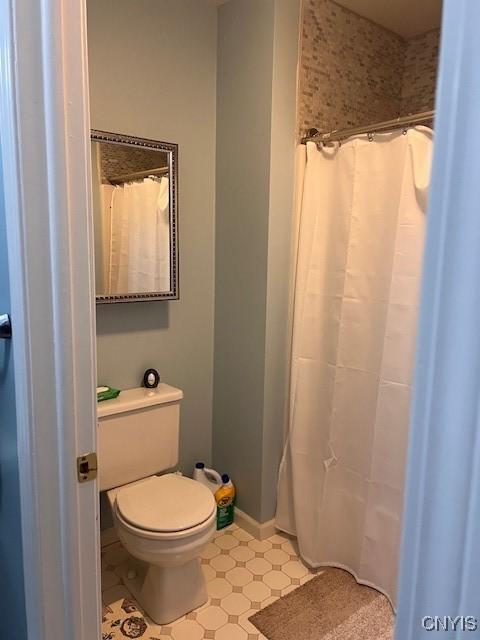 bathroom featuring a shower with curtain and toilet