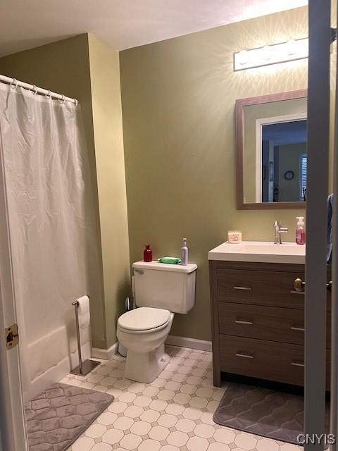 bathroom featuring vanity, curtained shower, and toilet