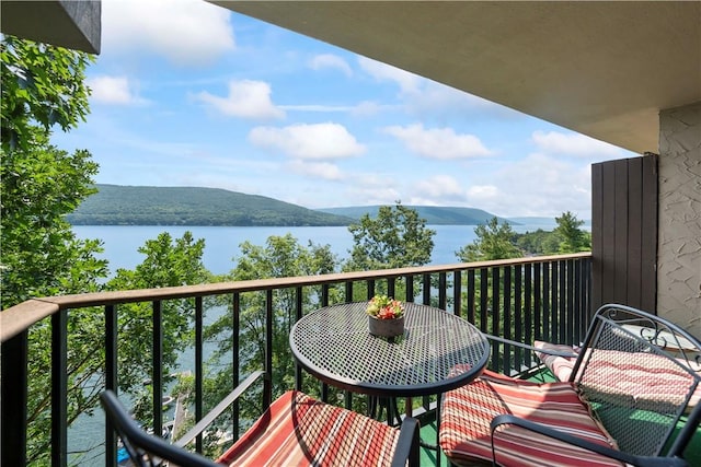 balcony featuring a water and mountain view