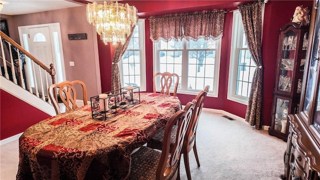 carpeted dining space featuring an inviting chandelier