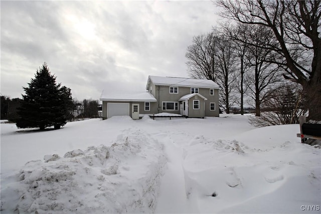 snow covered property with a garage