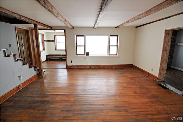 empty room with dark hardwood / wood-style floors and beam ceiling