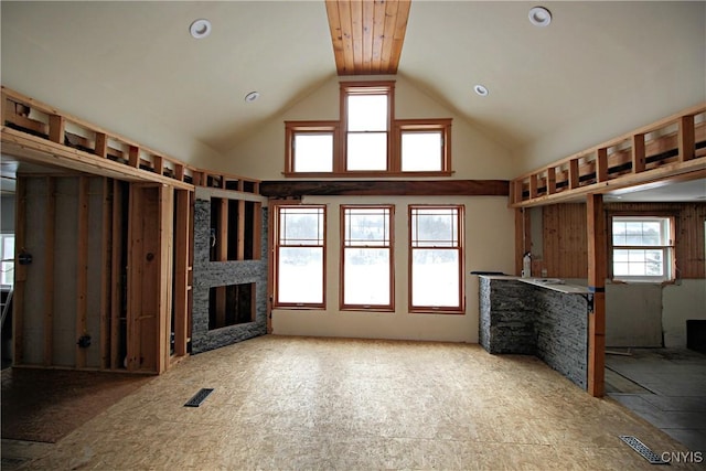 unfurnished living room with a fireplace and high vaulted ceiling