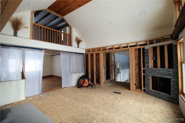 unfurnished living room with high vaulted ceiling