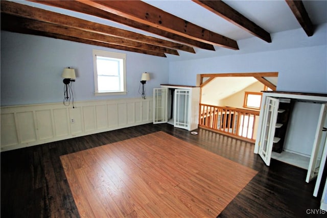 interior space with dark wood-type flooring and beam ceiling