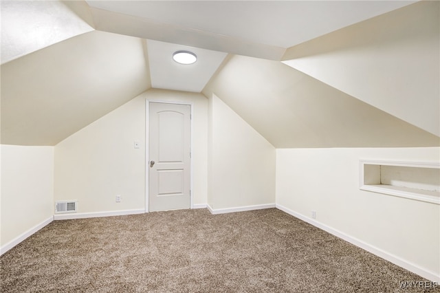 additional living space featuring lofted ceiling and carpet