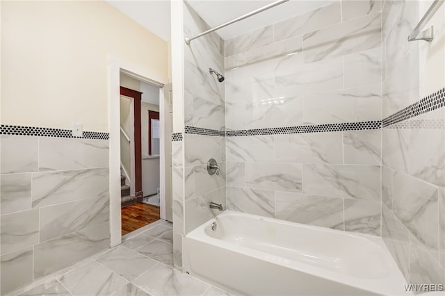 bathroom featuring tiled shower / bath combo and tile walls