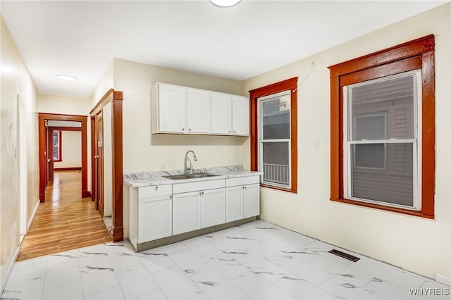 kitchen featuring sink and white cabinets