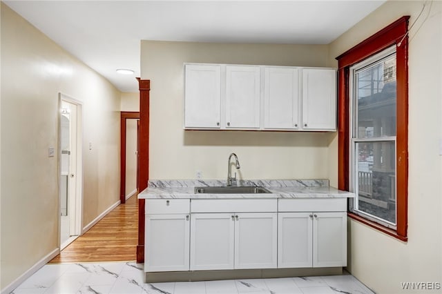 kitchen featuring white cabinetry and sink