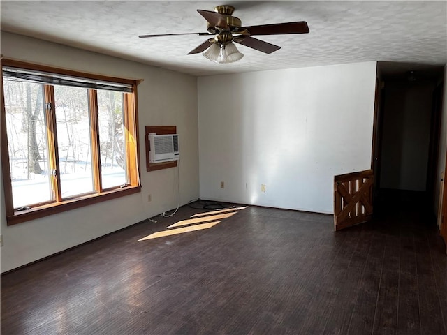 unfurnished room featuring a textured ceiling, wood finished floors, a wall mounted air conditioner, and a ceiling fan