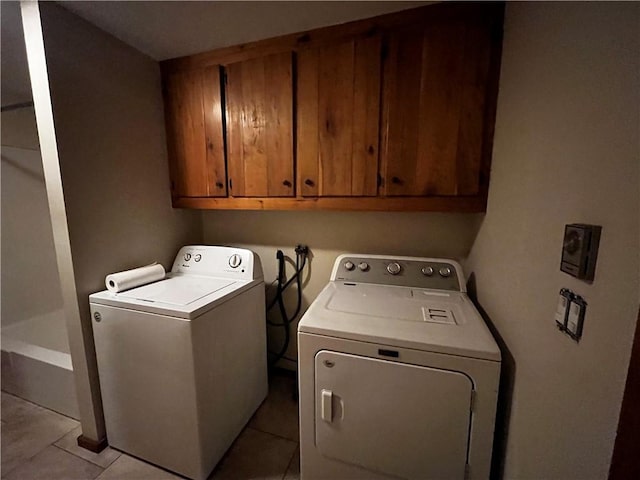 laundry area featuring light tile patterned floors, cabinets, and independent washer and dryer