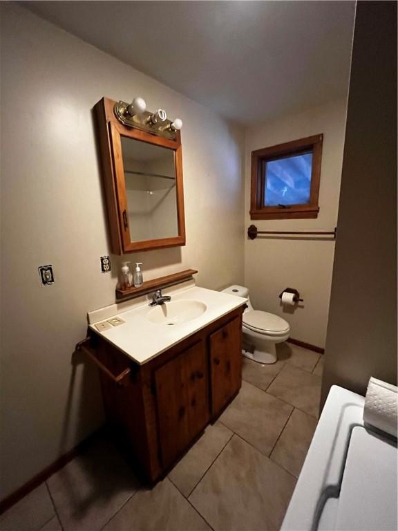 bathroom featuring toilet, vanity, and tile patterned flooring