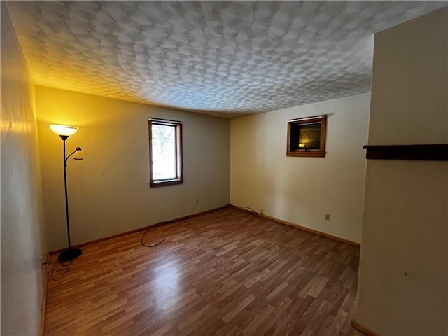 spare room with hardwood / wood-style floors and a textured ceiling