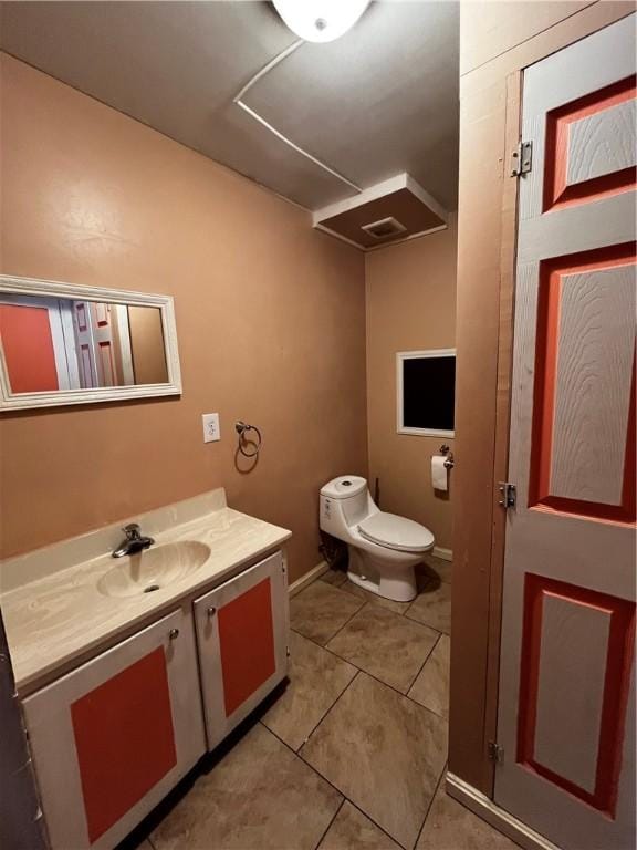 half bathroom featuring tile patterned floors, vanity, and toilet