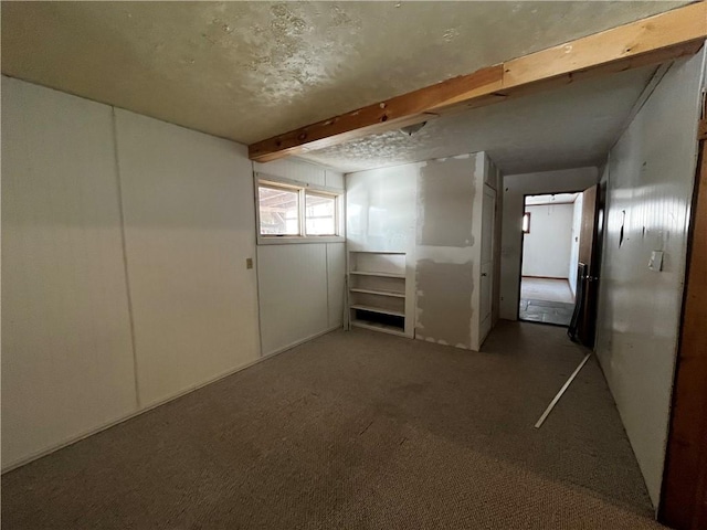 carpeted spare room with beam ceiling