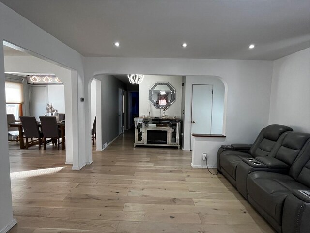 49 Lewis St, Maine, NY 13760 - living area with arched walkways, light wood finished floors, recessed lighting, a chandelier, and baseboards