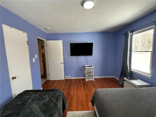 bedroom with dark wood-type flooring