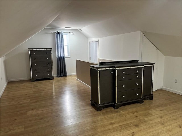 bonus room featuring lofted ceiling and light hardwood / wood-style flooring