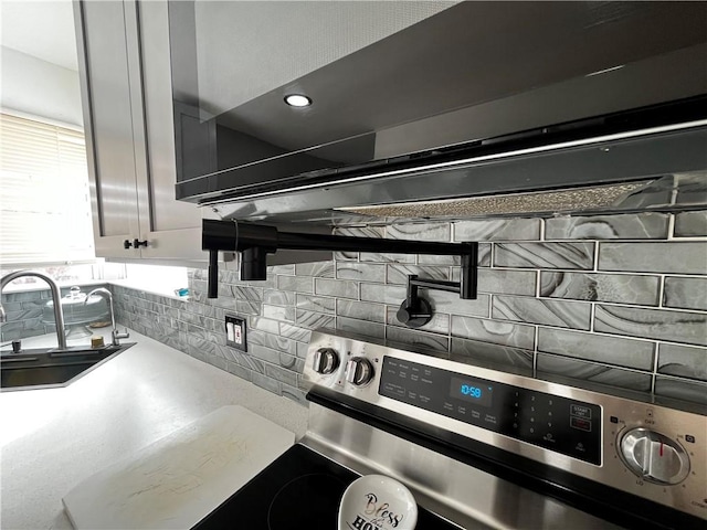 interior details with tasteful backsplash, sink, and stainless steel electric range