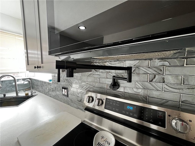 49 Lewis St, Maine, NY 13760 - kitchen view of backsplash, a sink, stainless steel electric stove, exhaust hood, and light countertops