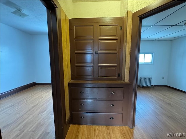 hallway with radiator and light hardwood / wood-style flooring