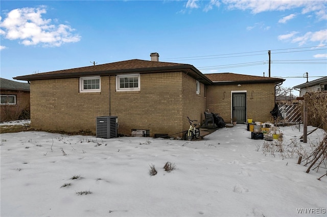 snow covered house featuring cooling unit