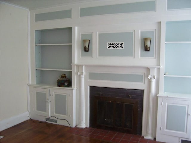 unfurnished living room featuring built in shelves and dark hardwood / wood-style floors