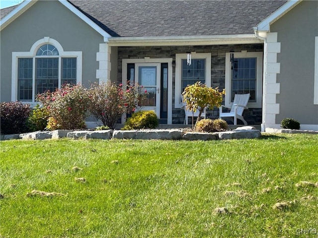 view of exterior entry with a yard