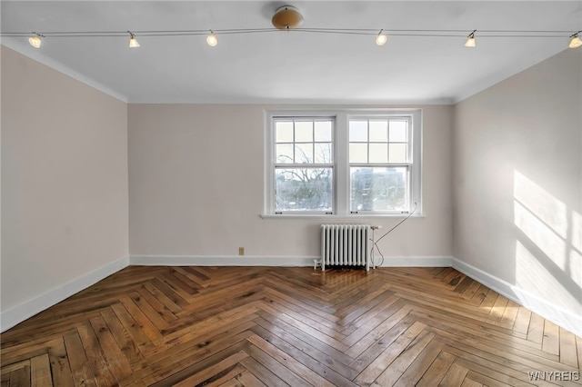 empty room featuring radiator and parquet flooring