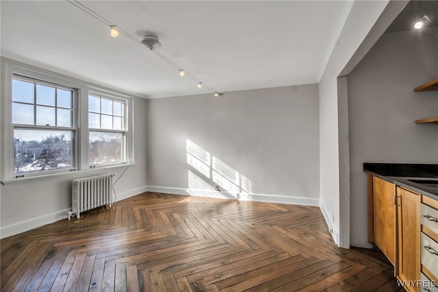 unfurnished living room featuring radiator heating unit and dark parquet floors