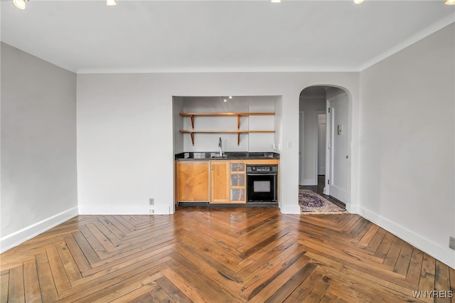 kitchen with sink, black oven, and parquet flooring