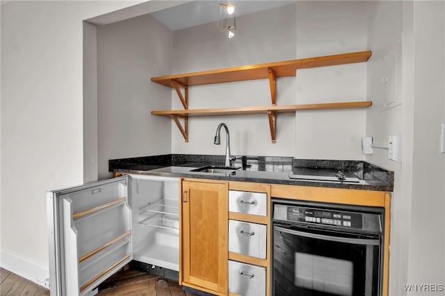 kitchen with sink, dark wood-type flooring, and black appliances