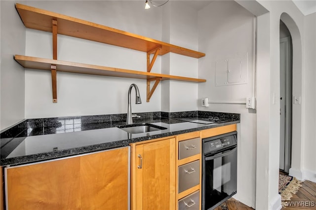 kitchen featuring dark stone countertops, sink, and black appliances