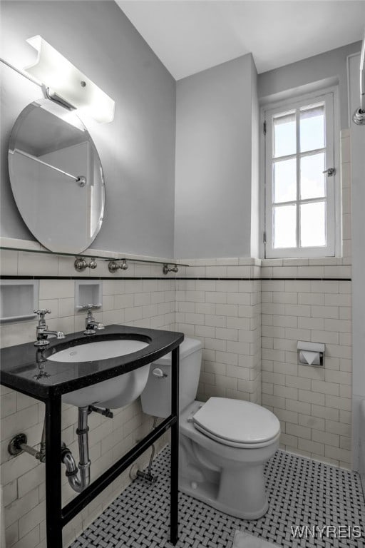 bathroom featuring sink, toilet, tile patterned flooring, and tile walls