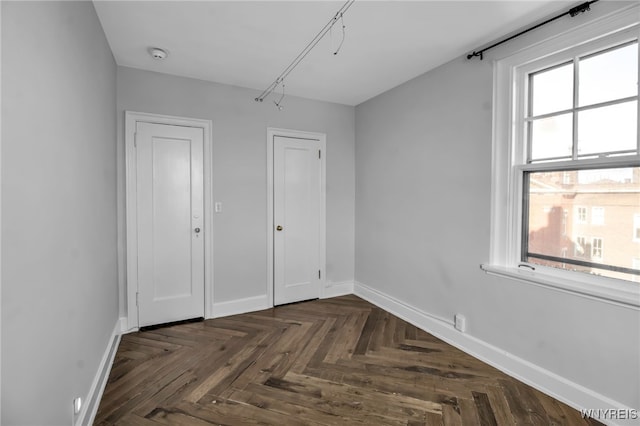 unfurnished bedroom featuring dark parquet flooring