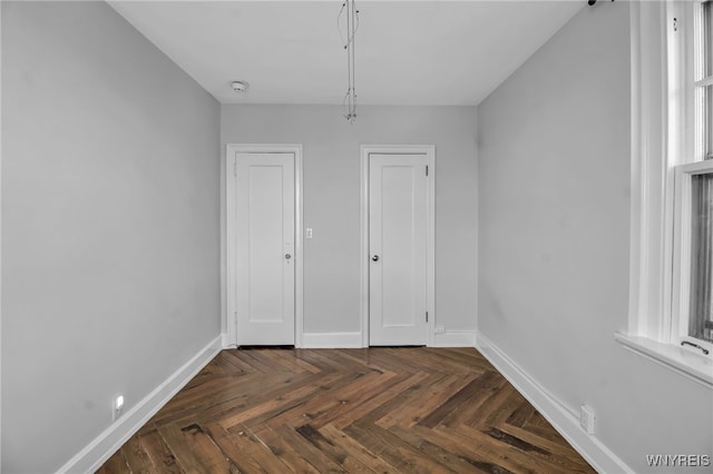 unfurnished bedroom with dark parquet flooring