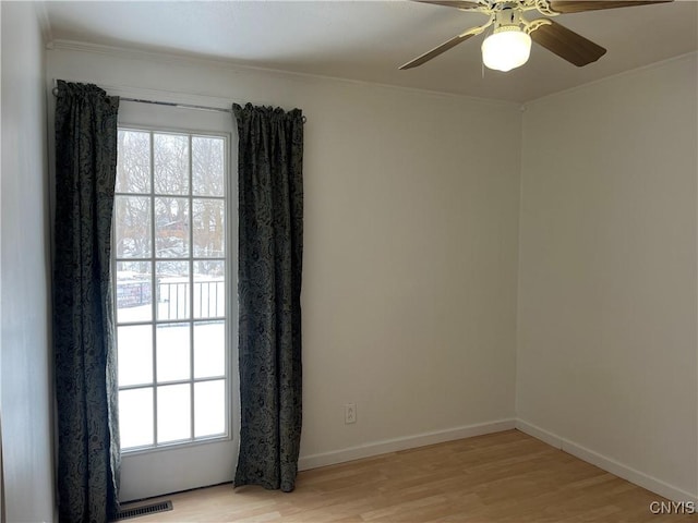 spare room with light hardwood / wood-style flooring, ornamental molding, and ceiling fan