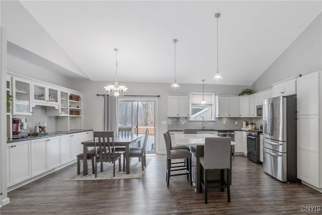 kitchen featuring white cabinetry, decorative light fixtures, stainless steel appliances, and a center island