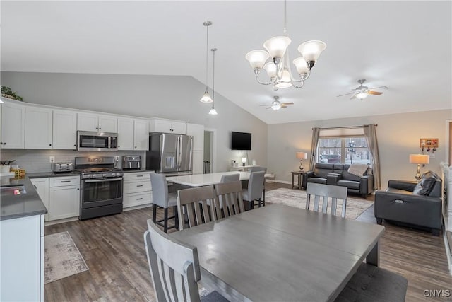 dining room featuring dark hardwood / wood-style flooring, high vaulted ceiling, sink, and ceiling fan