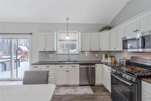 kitchen with hanging light fixtures, white cabinetry, appliances with stainless steel finishes, and sink