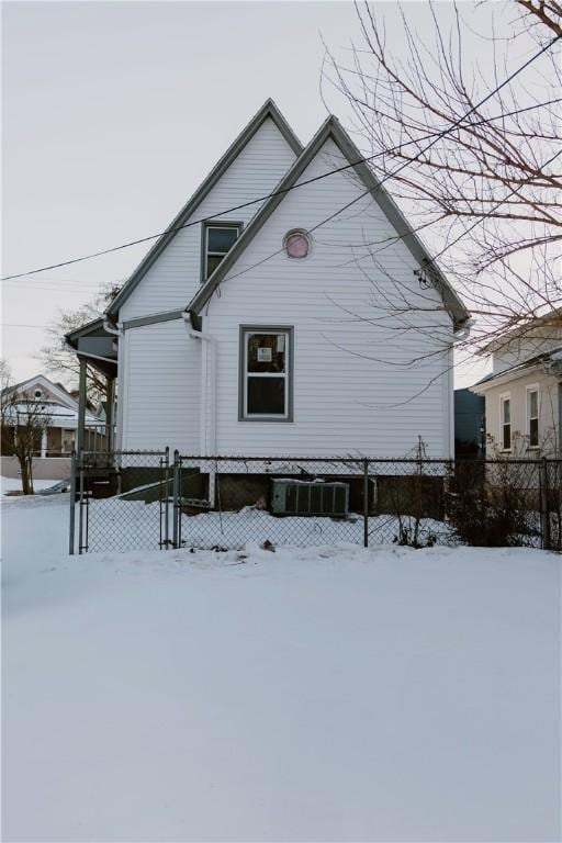 snow covered property featuring fence and central air condition unit