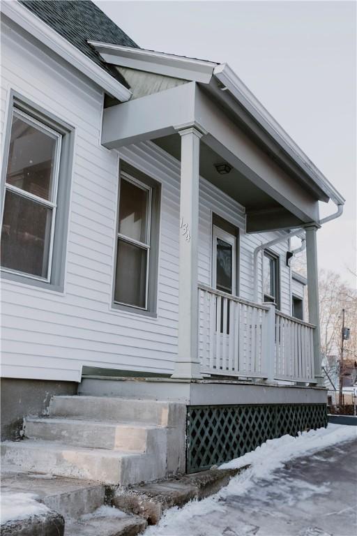 view of home's exterior featuring a porch and a shingled roof