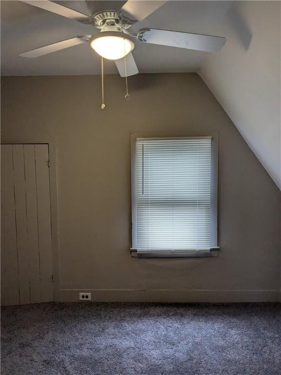 spare room with vaulted ceiling, carpet flooring, and a ceiling fan