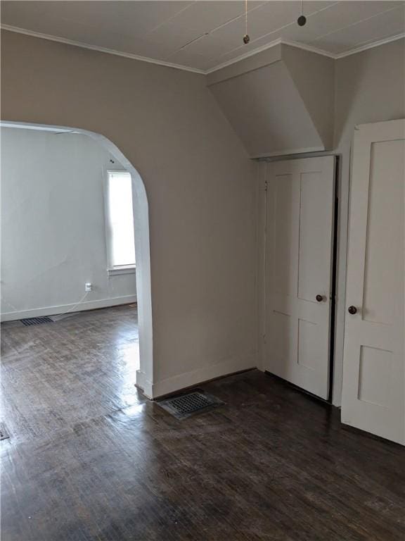 bonus room featuring baseboards, visible vents, arched walkways, and dark wood finished floors