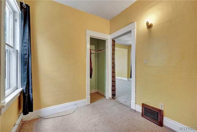 unfurnished bedroom featuring multiple windows and light colored carpet