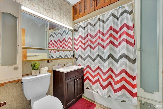 bathroom with vanity, toilet, and tile walls