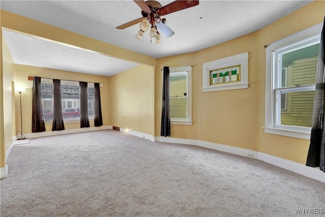 spare room with ceiling fan, a textured ceiling, and carpet