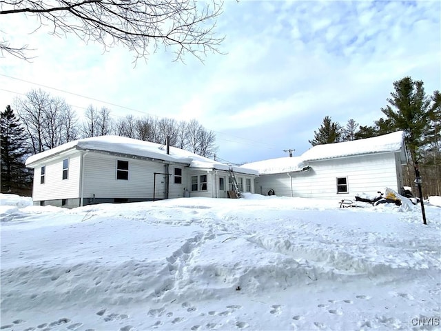 view of snow covered back of property