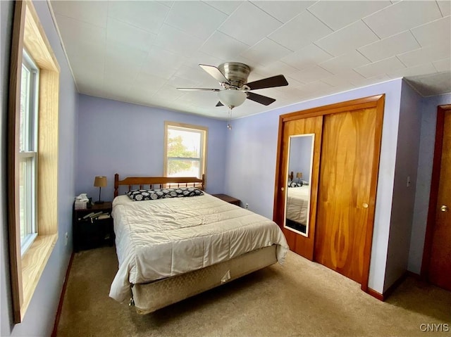 bedroom with ceiling fan, a closet, and carpet