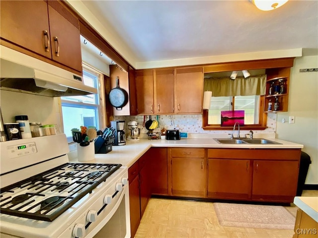 kitchen with sink, white gas range oven, and backsplash